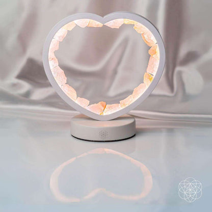 Rose quartz heart lamp with gray frame and glowing ring on a white base