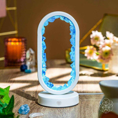 White oval clear quartz lamp with glowing blue energy edge on a round base