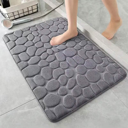 Grey bath rug with cobblestone embossed pattern and plush, cushioned surface