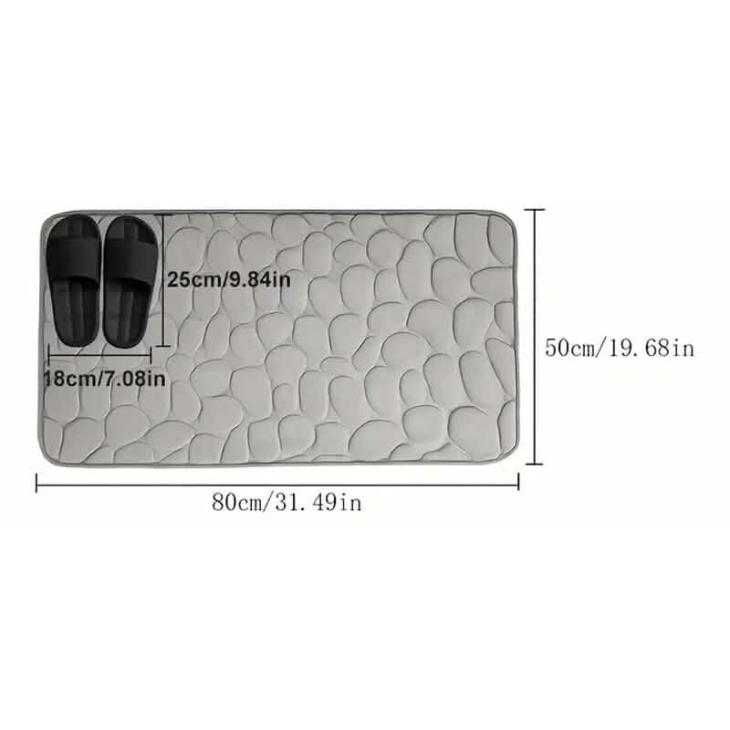 Rectangular bath rug with cobblestone embossed texture and size diagram markings
