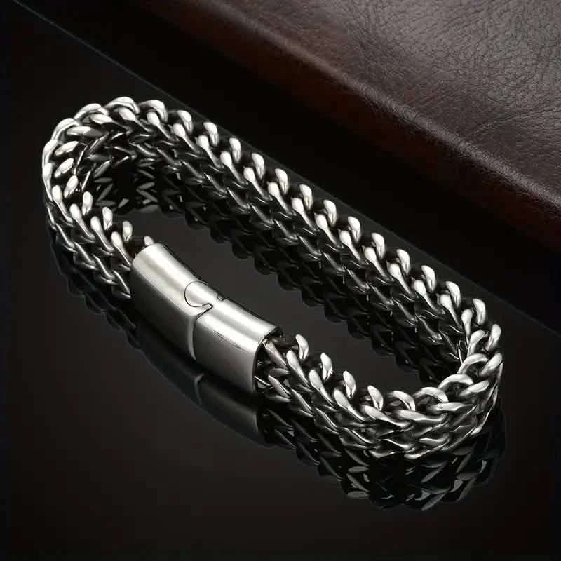 Braided stainless steel bracelet with magnetic clasp centerpiece, close-up of chain links.