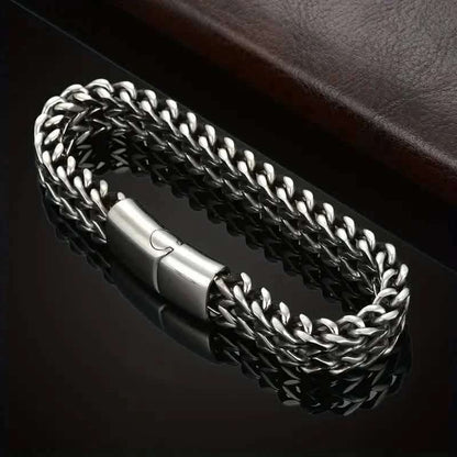 Braided stainless steel bracelet with magnetic clasp centerpiece, close-up of chain links.