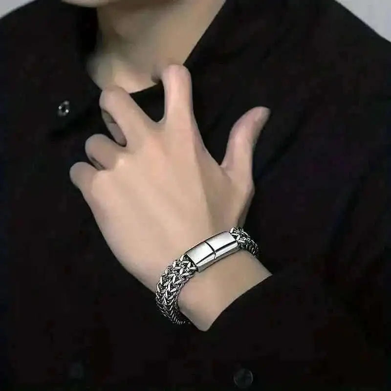 Stainless steel magnetic clasp bracelet on wrist, braided chain cuff with clasp detail.