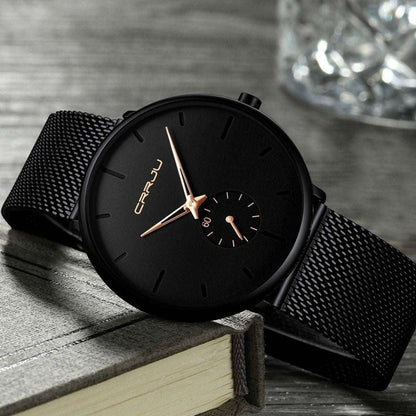 Minimalist black wrist watch with black mesh strap, black dial, gold hands and small subdial