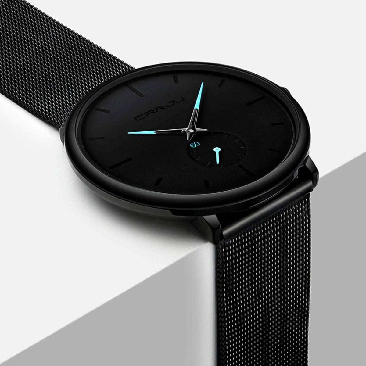 Black minimalist wrist watch with black mesh band, black dial, teal hands and markers