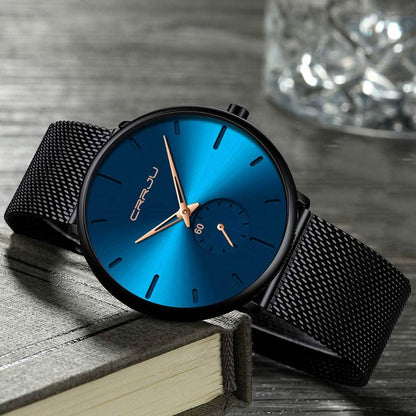 Blue minimalist wrist watch with black mesh band, blue dial and gold-toned accents
