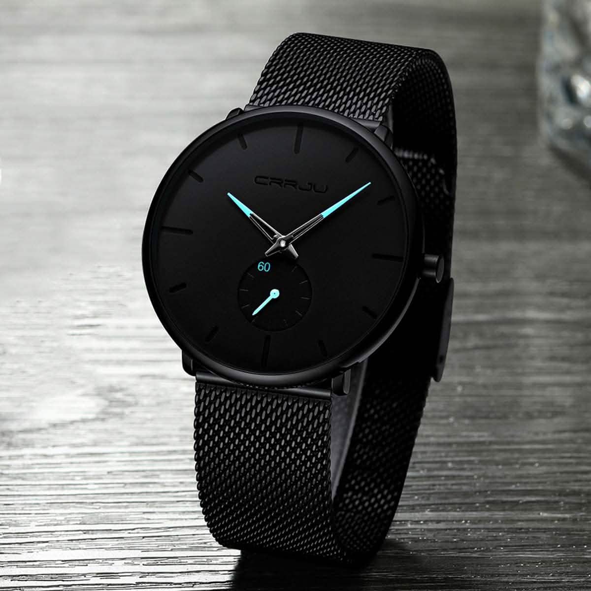 Black minimalist wrist watch with black mesh band and dark round dial, teal hands