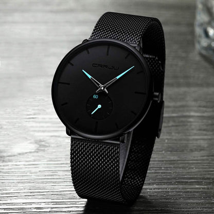 Black minimalist wrist watch with black mesh band and dark round dial, teal hands