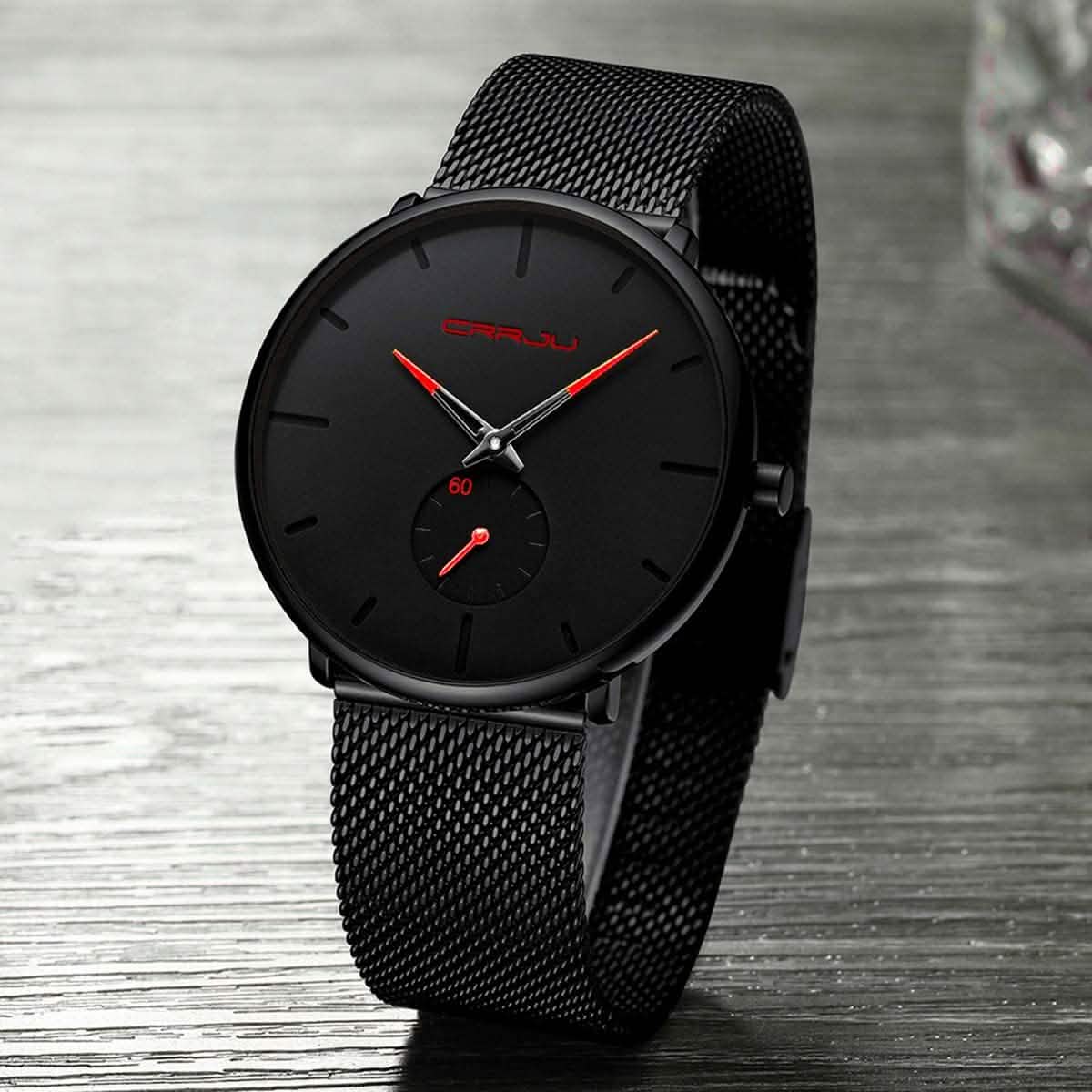 Black minimalist wrist watch with round dial, red accents, and black mesh strap