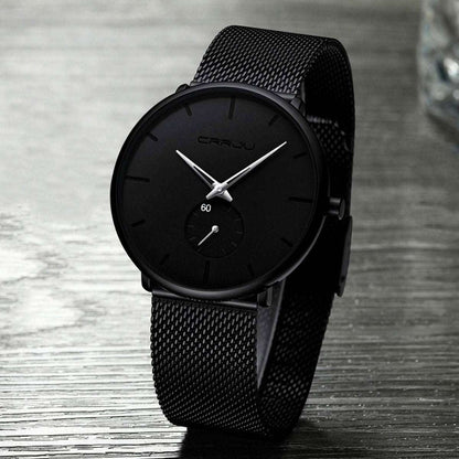 Black minimalist wrist watch with black dial and black mesh strap, angled view