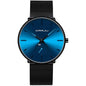 Blue minimalist wrist watch front view, black mesh band, round blue dial and dark bezel