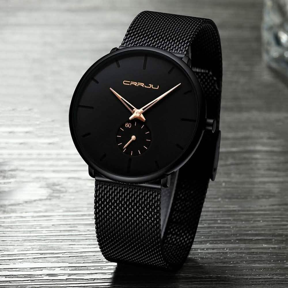 Minimalist black wrist watch with black mesh strap, black dial, gold hour markers and subdial