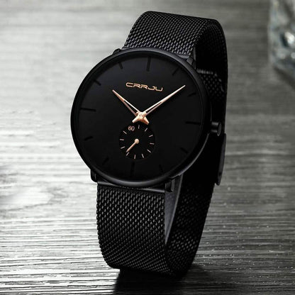 Minimalist black wrist watch with black mesh strap, black dial, gold hour markers and subdial