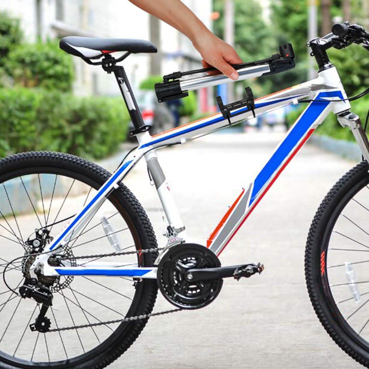 Portable bike tire inflator pump mounted near handlebars on a road bike