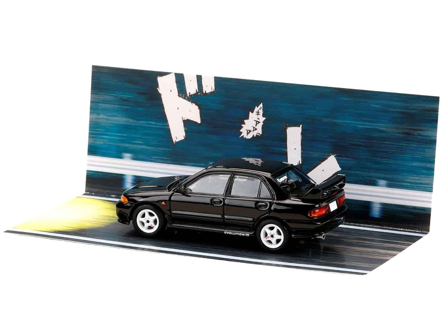 Black diecast Lancer Evolution III car posed on blue street diorama backdrop