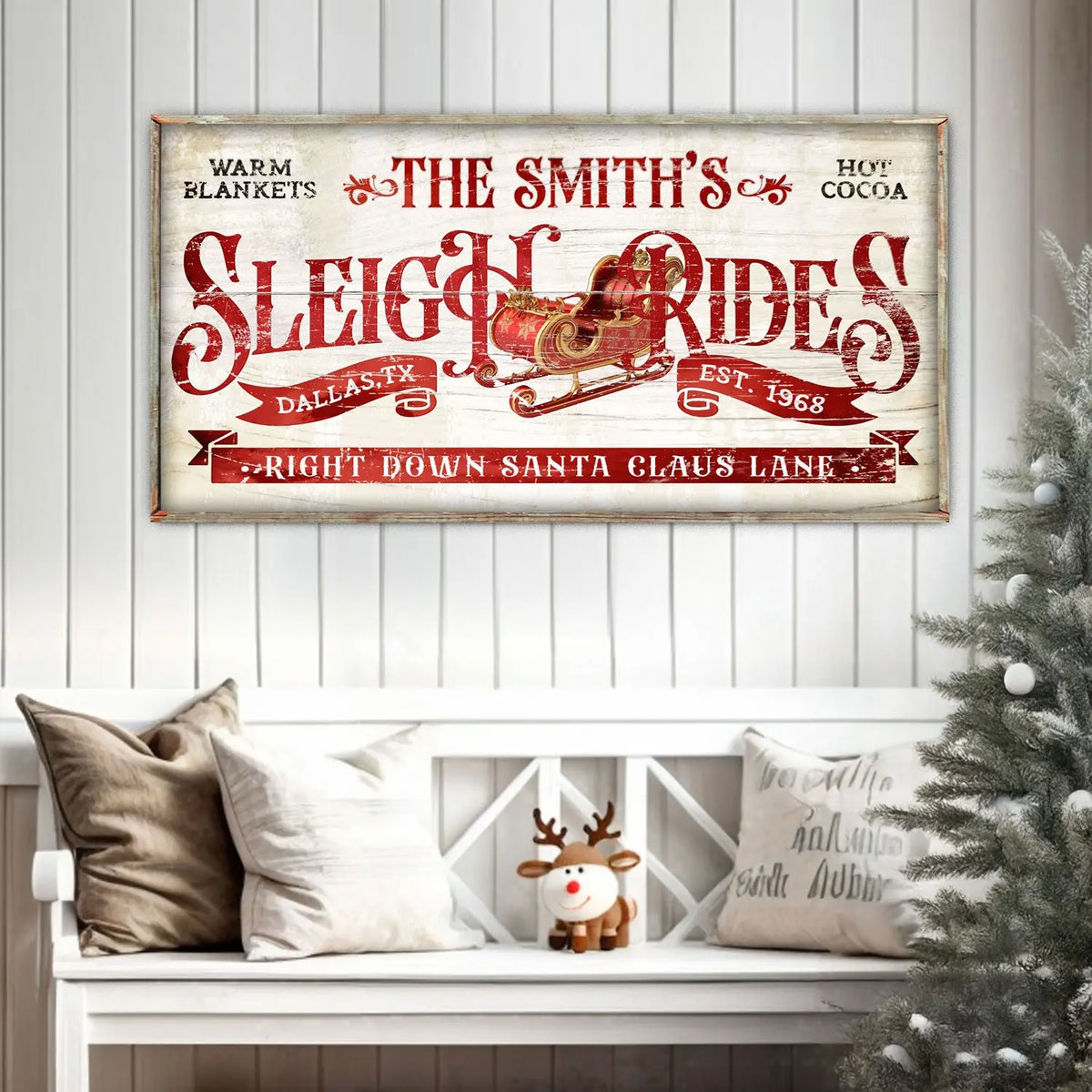 Framed Christmas wall sign above bench, featuring red sleigh ride typography