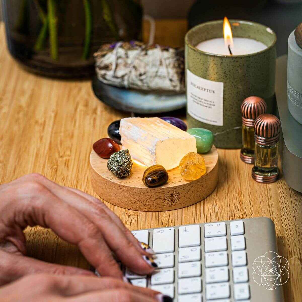 Money-magnet lamp on wooden tray with crystals and lit candle