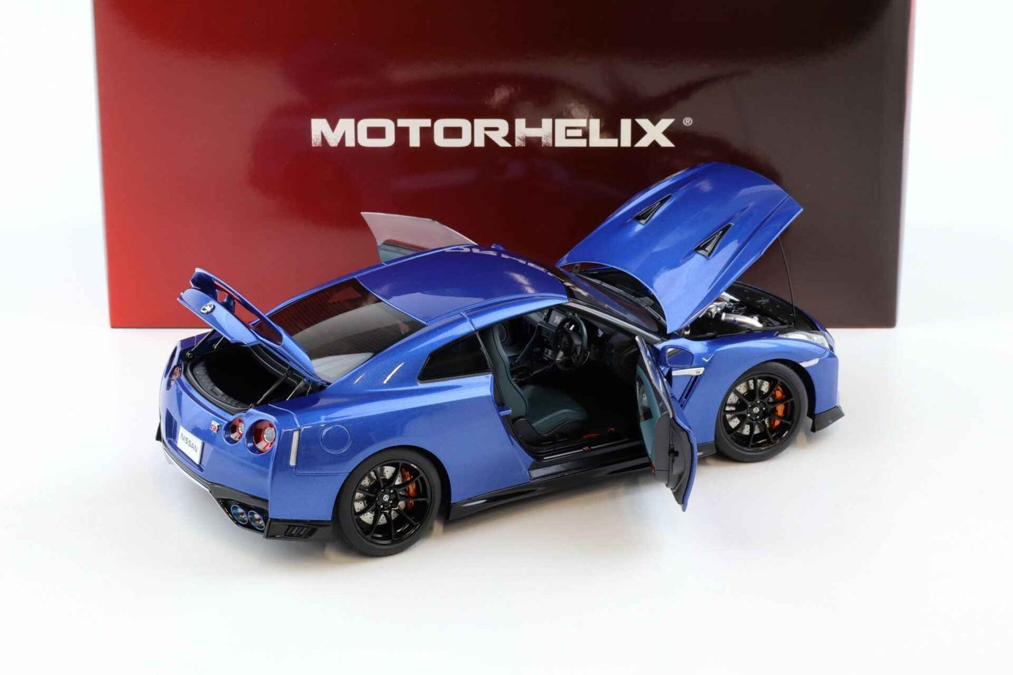 Blue die-cast sports car model, open door and trunk, black wheels