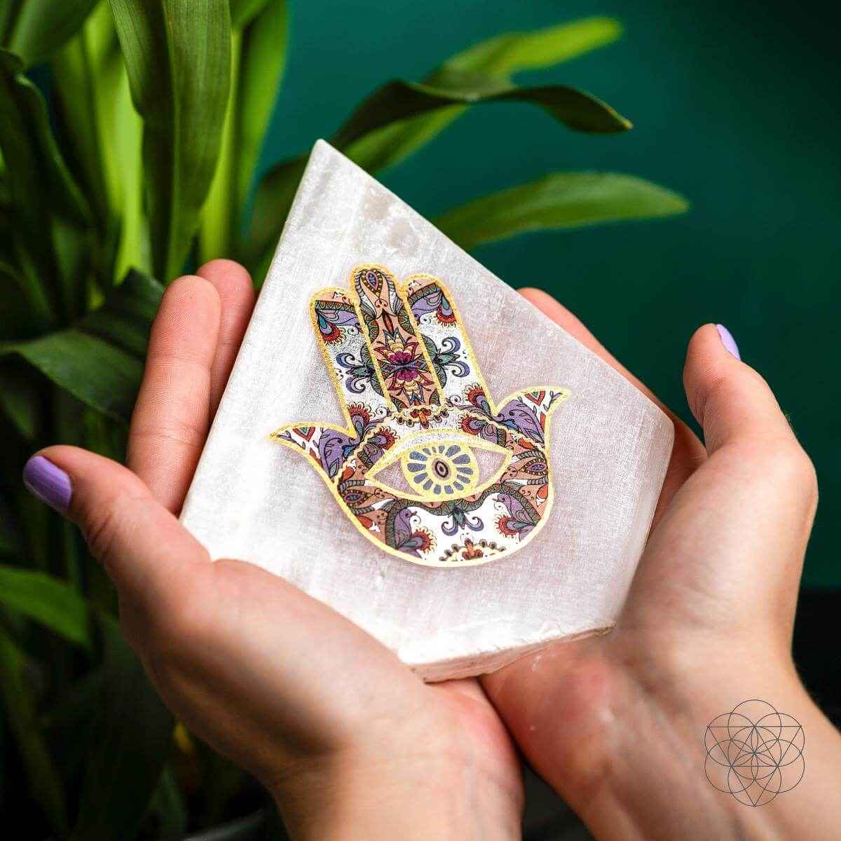 Hamsa-pattern triangular mood lamp being held in hands