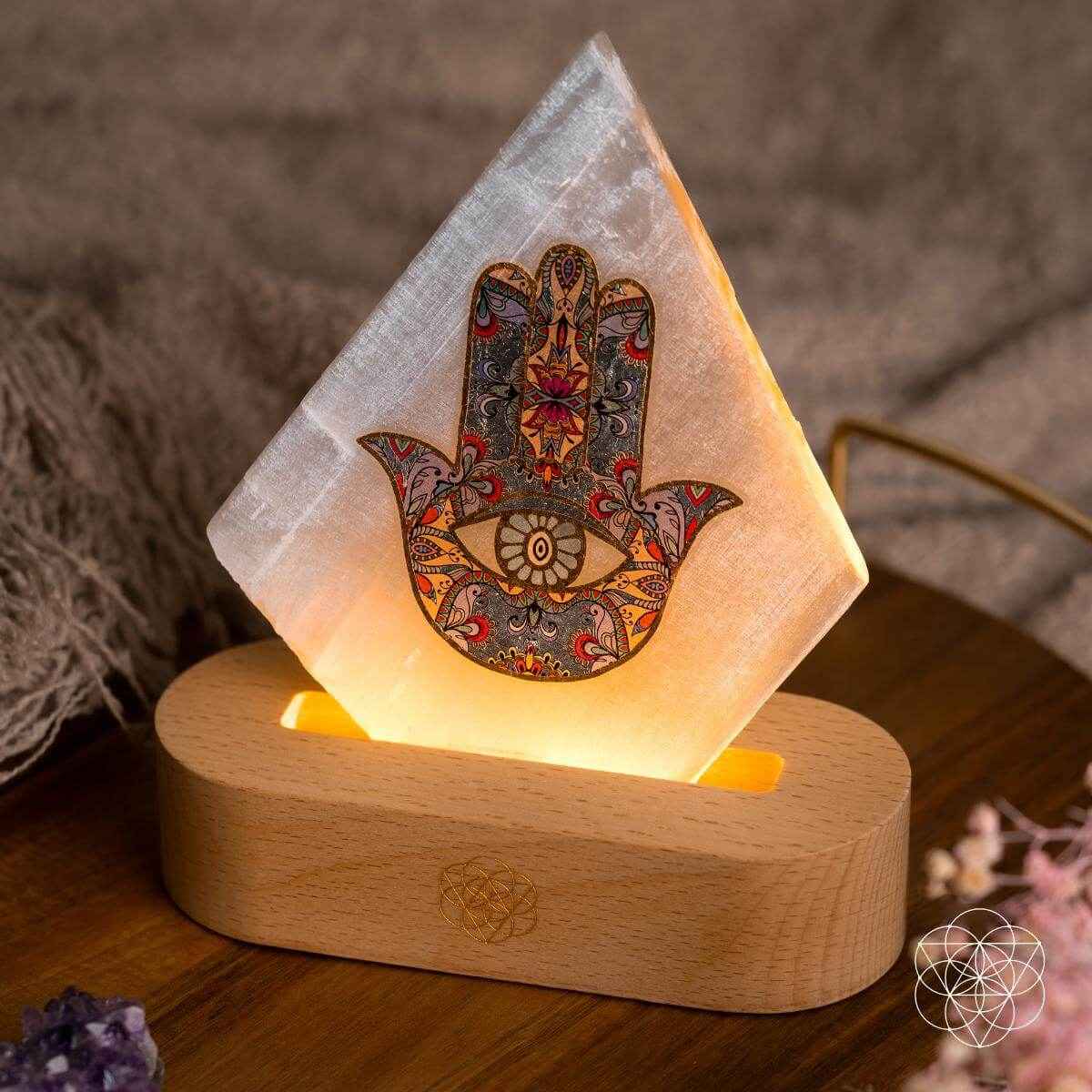 Triangular hamsa-pattern mood lamp with warm light on wooden base