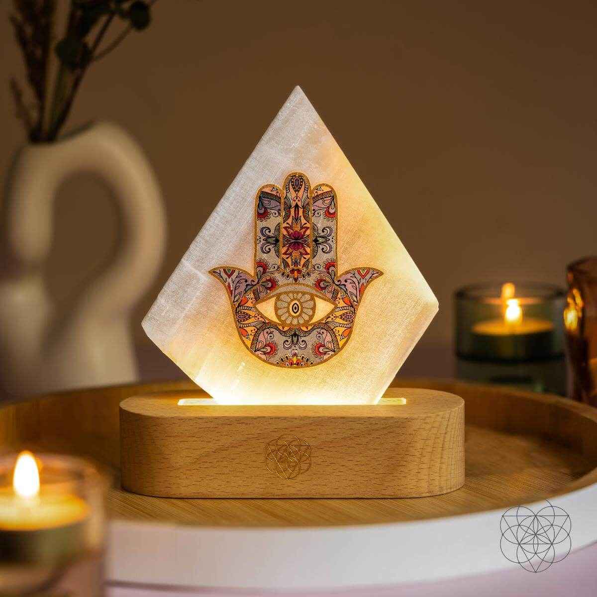 Triangular hamsa-pattern mood lamp with warm glow on round wooden base