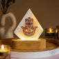Triangular hamsa-pattern mood lamp with warm glow on round wooden base