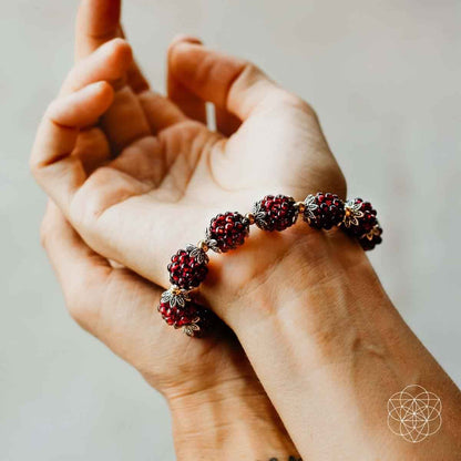 Natural garnet healing bracelet with red beaded strands and gold floral bead caps