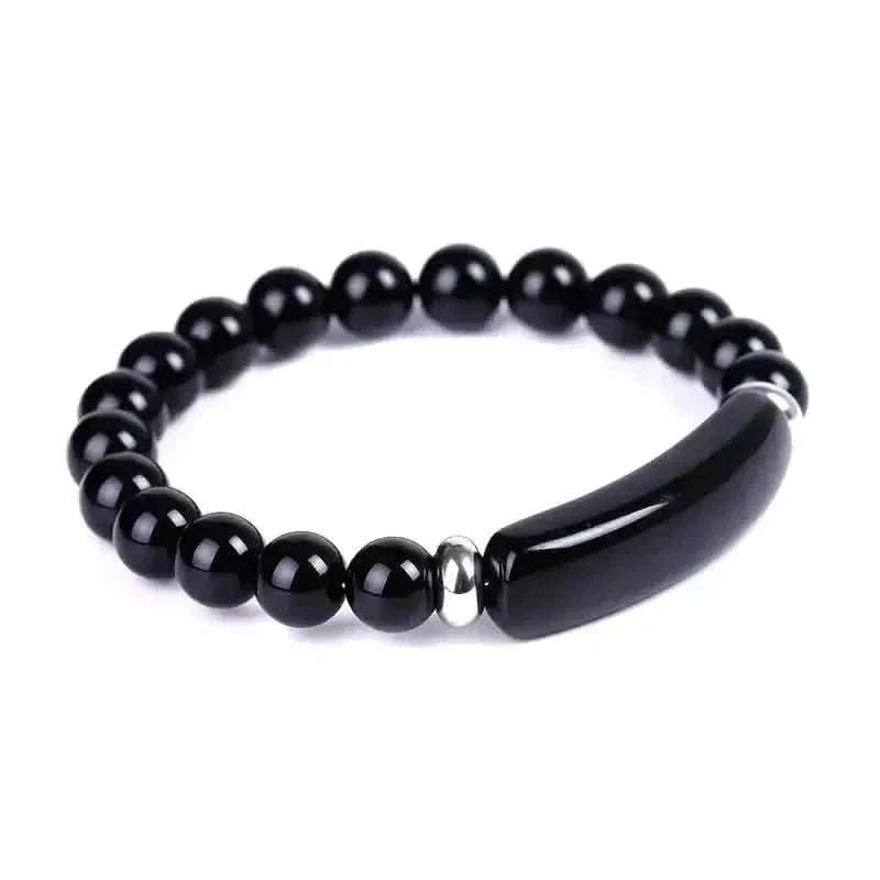 Black gemstone beaded bracelet with a curved dark horn-like centerpiece and silver spacers