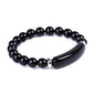 Black gemstone beaded bracelet with a curved dark horn-like centerpiece and silver spacers