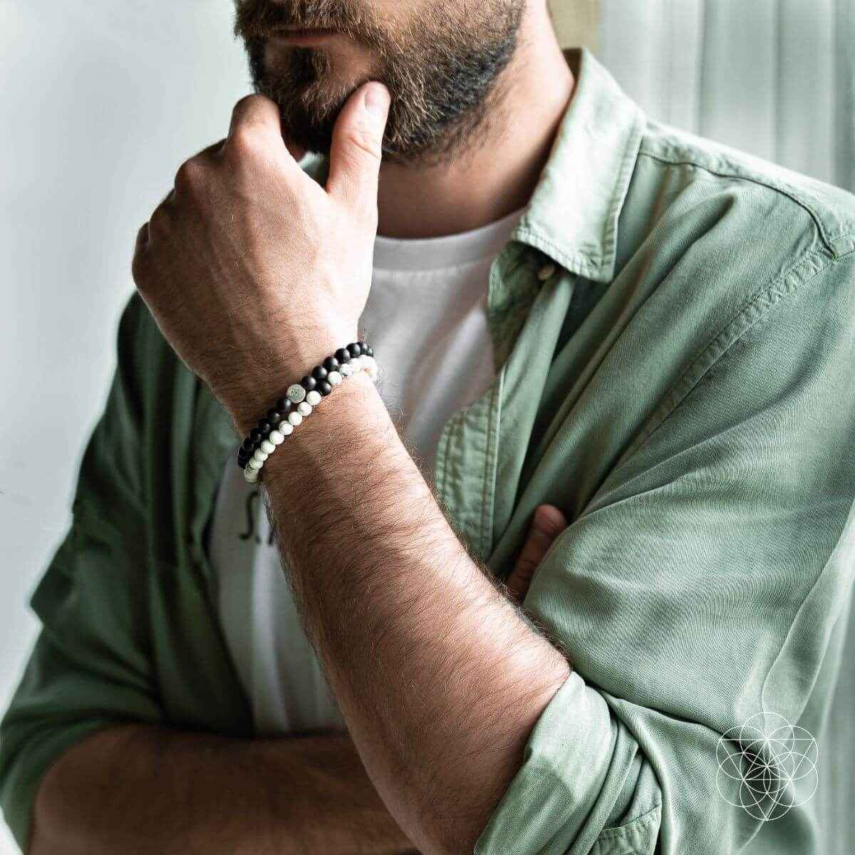 Black-and-white beaded bracelet set on a man’s wrist with silver-toned bead accents