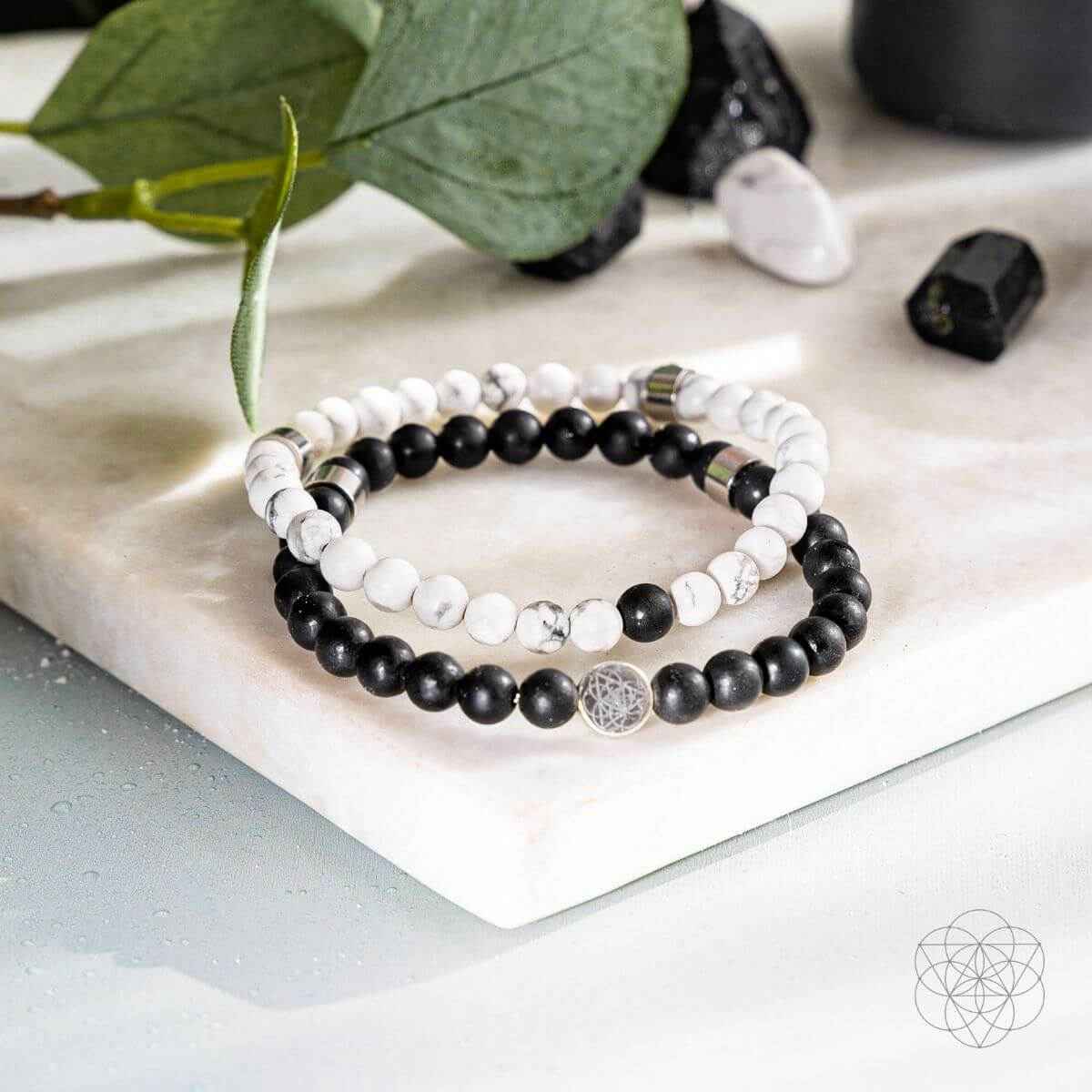 Beaded bracelet set with black and white beads and a silver-toned charm centerpiece