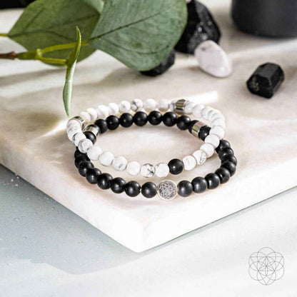 Beaded bracelet set with black and white beads and a silver-toned charm centerpiece