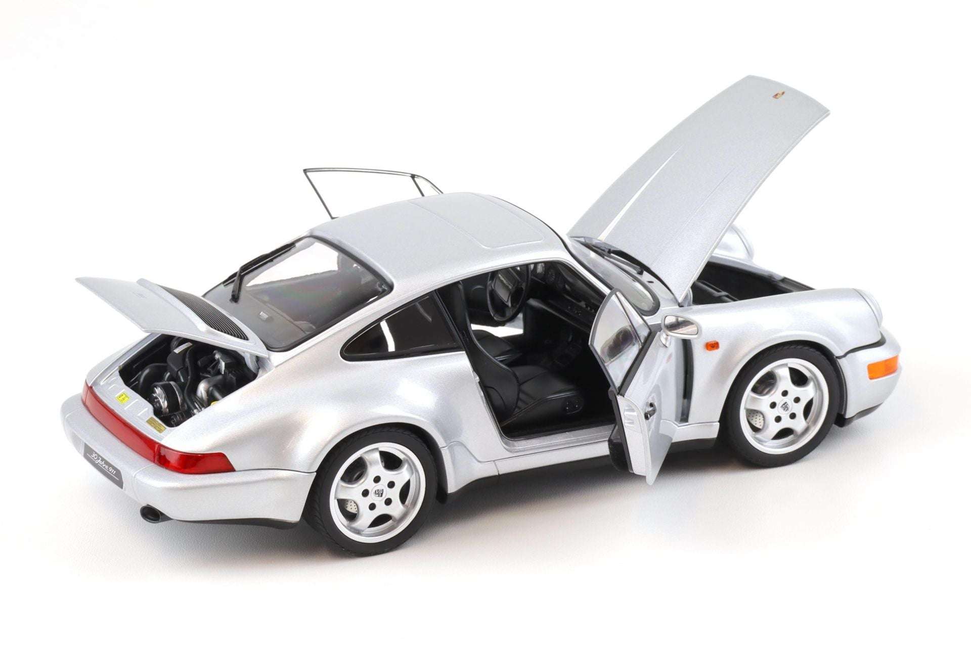 Silver Porsche 911 die-cast model car, doors open with hood up, four-spoke wheels