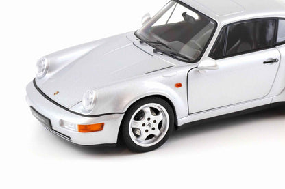 Silver Porsche 911 die-cast model car close-up, front bumper, headlights, and four-spoke wheel