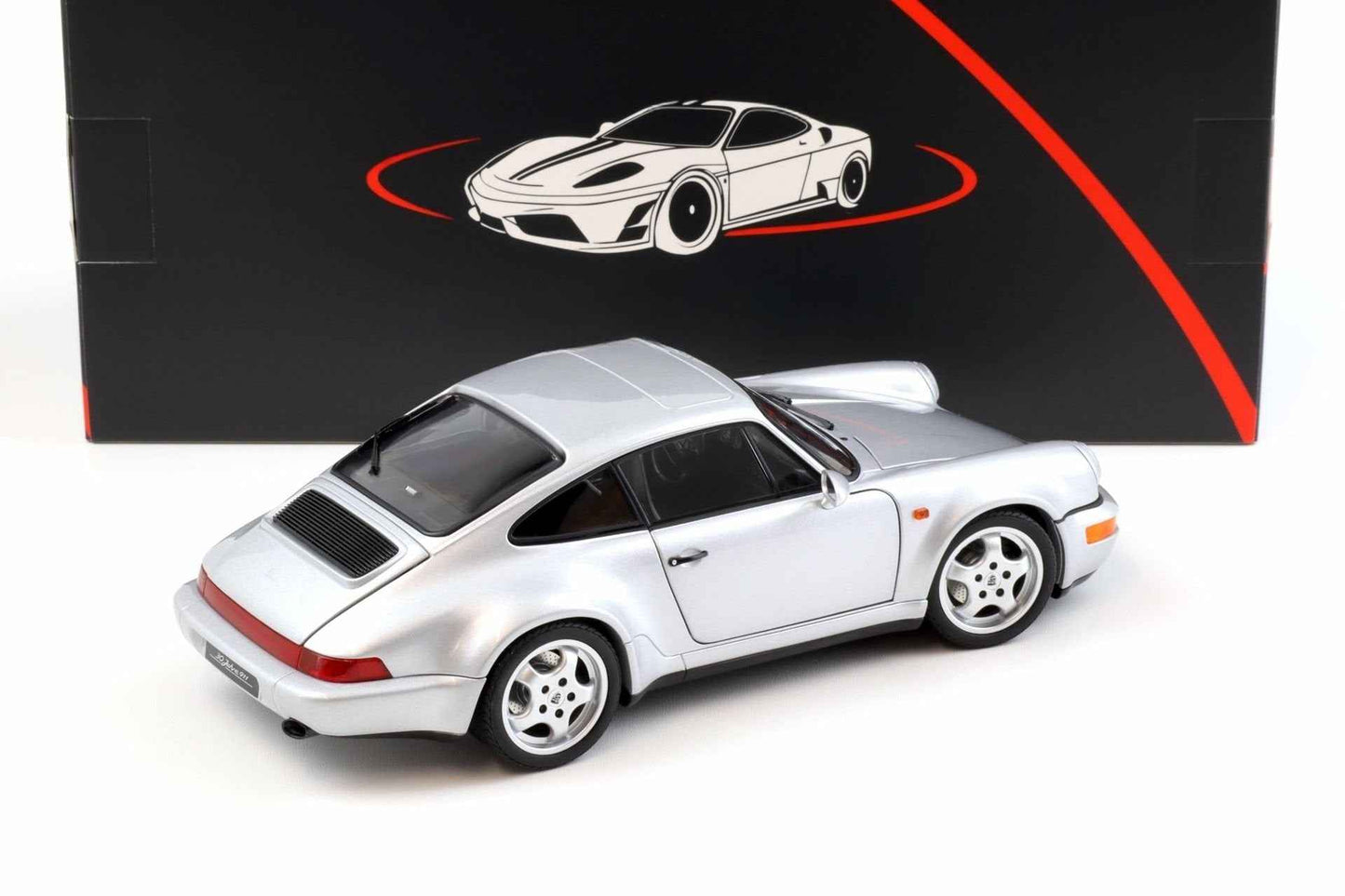 Silver Porsche 911 die-cast model car, rear three-quarter view with rear spoiler and four-spoke wheels