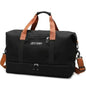Nylon duffel bag in black with tan handles and front zipper pocket, crossbody strap.