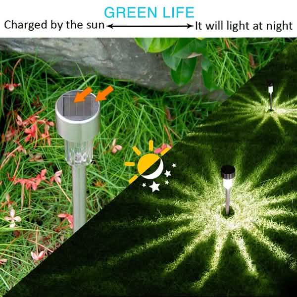 Outdoor solar LED garden stake light with clear globe and black top on grass
