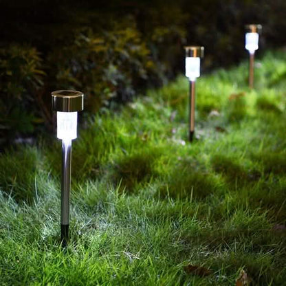 Outdoor solar LED garden lights with white glow on dark metal spike stakes