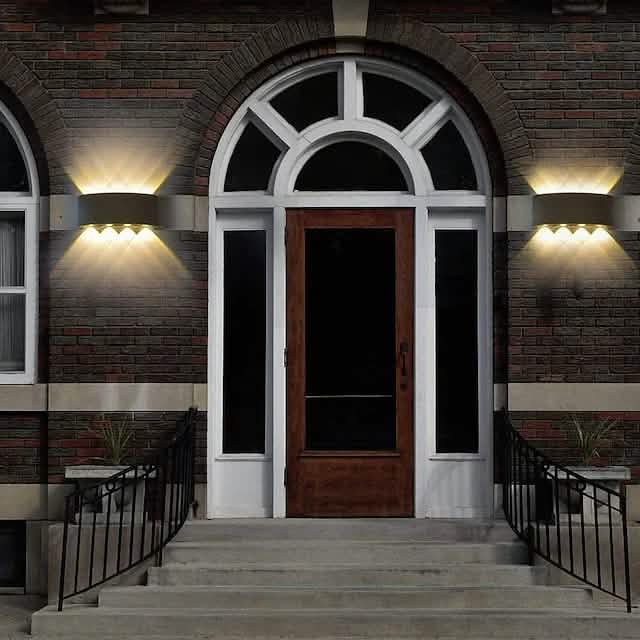 Pair of black outdoor waterproof wall lights with warm LED glow