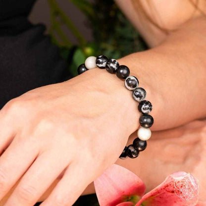 Zebra jasper beaded bracelet on wrist, black and white round stones on elastic cord