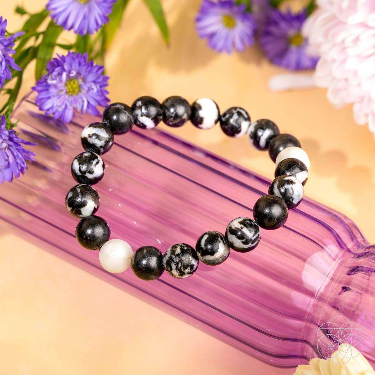 Zebra jasper beaded bracelet with black spheres, white beads, and zebra-pattern stones
