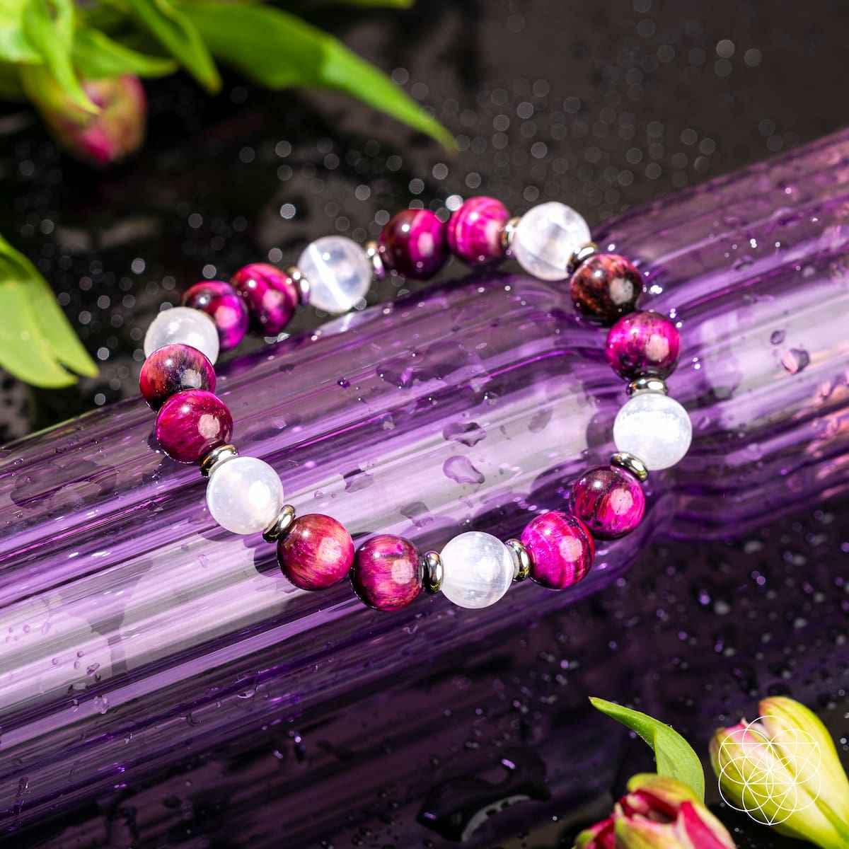 Close-up beaded bracelet with magenta beads, white stones, and silver spacers.