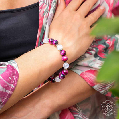 Bracelet worn on wrist with magenta beads and white stone bead accents.