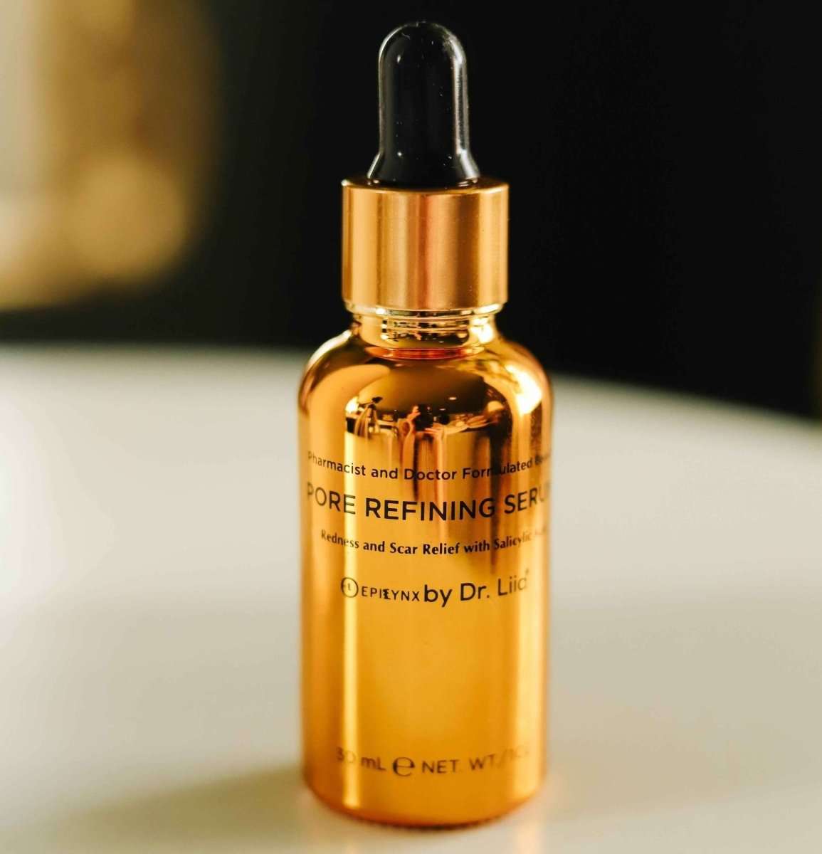 Amber serum bottle with black dropper, close-up view of front label