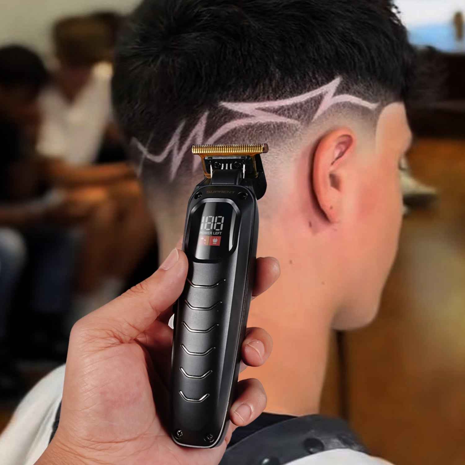 Handheld Black Scorpion hair trimmer near scalp with gold blade