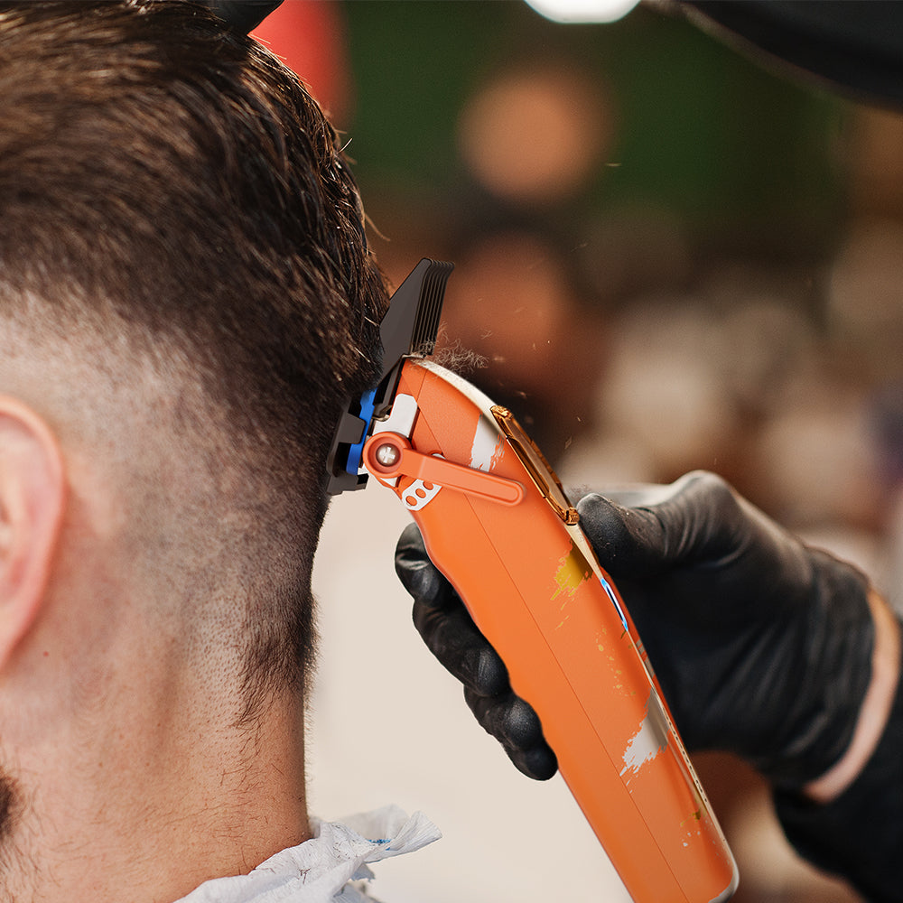 Orange hair clipper trimming short hair on the side of head