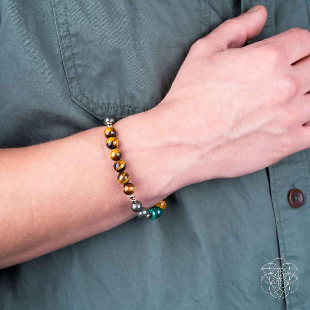 Beaded bracelet set on arm with brown tiger-eye, green stones, and silver-tone beads