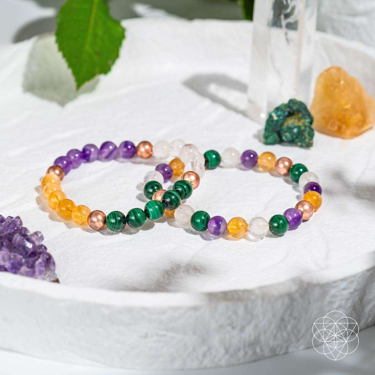 Crystal bracelet set on white cloth with purple, green, orange, and clear beads