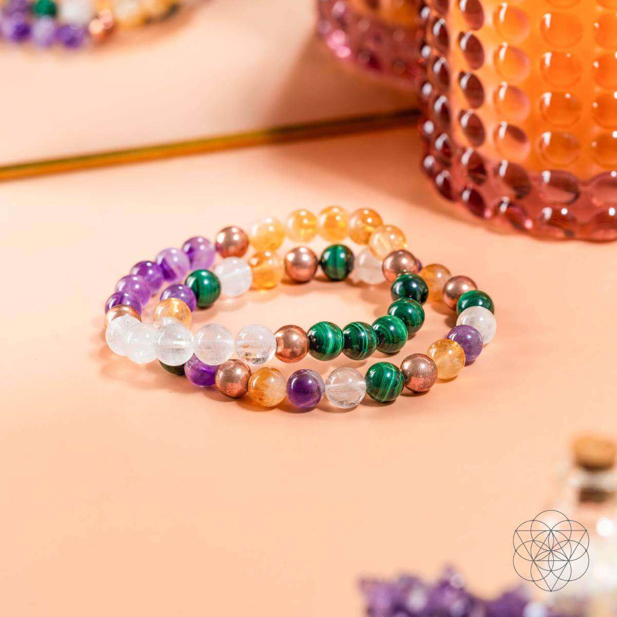 Close-up of beaded crystal bracelet set with purple, green, orange, and clear gemstone beads