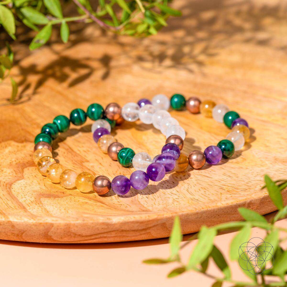 Beaded crystal bracelet set on wooden tray with purple, green, orange, and clear beads